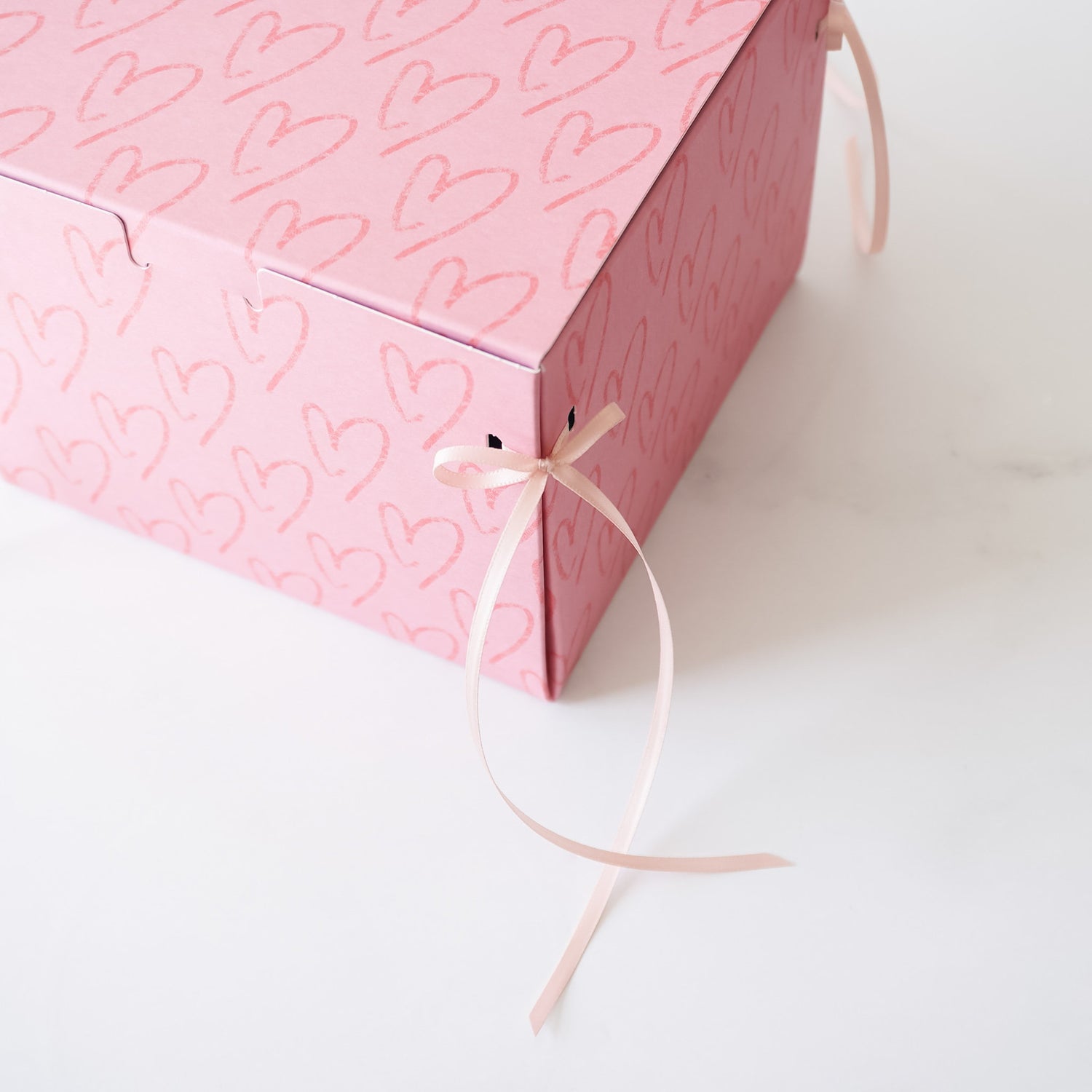 heart printed bakery box with pink ribbon