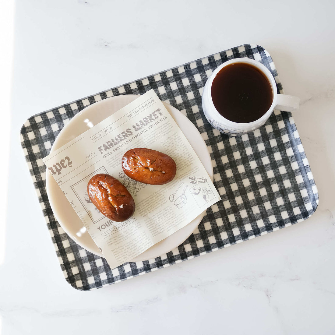 financier cake and a cup of coffee on a serving tray