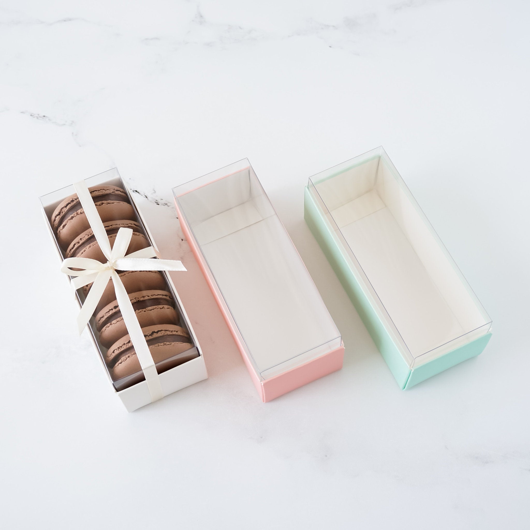 mini macaron boxes in white, pink, and mint