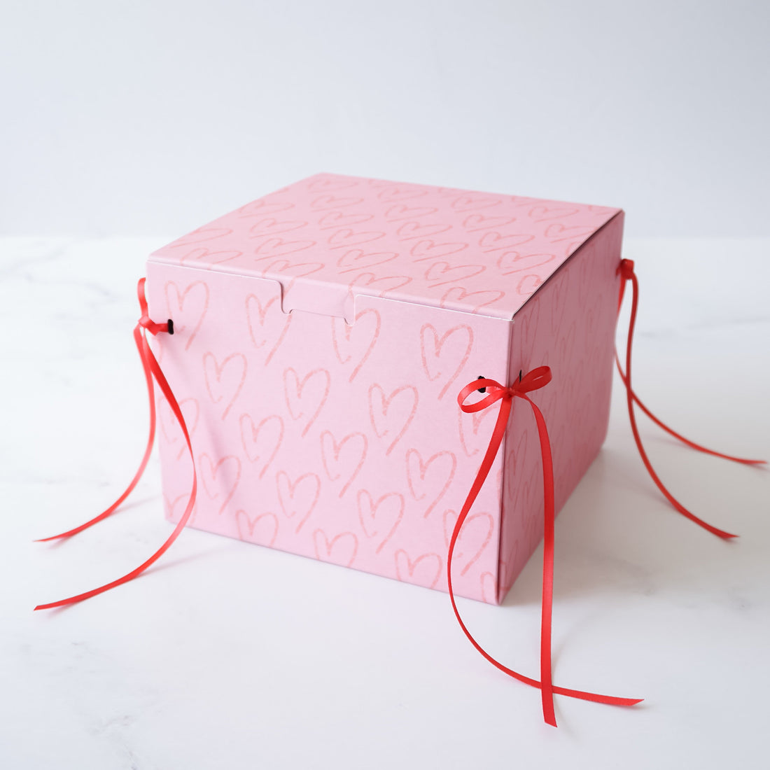 pink bakery box with red ribbon bow