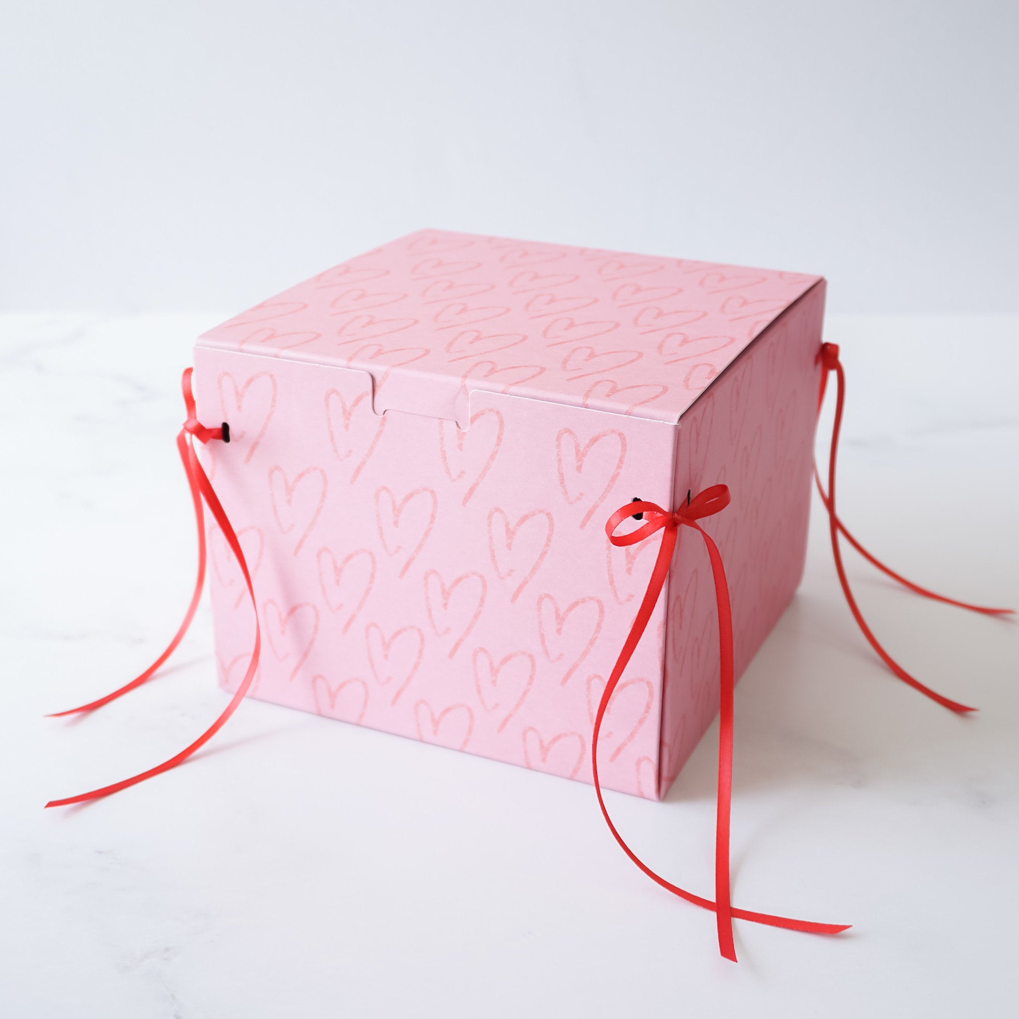 pink bakery box with red ribbon bow