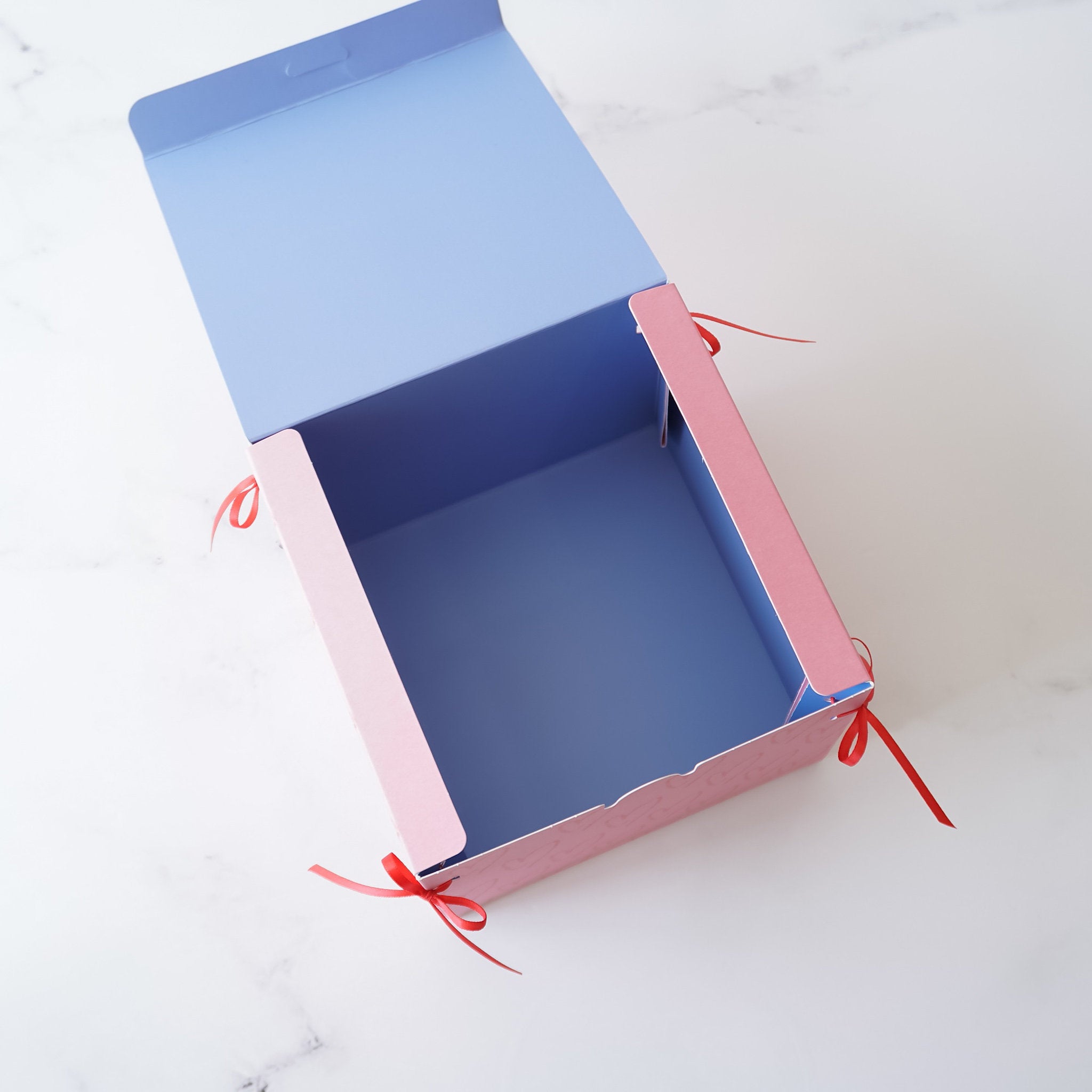 pink bakery box with red ribbon