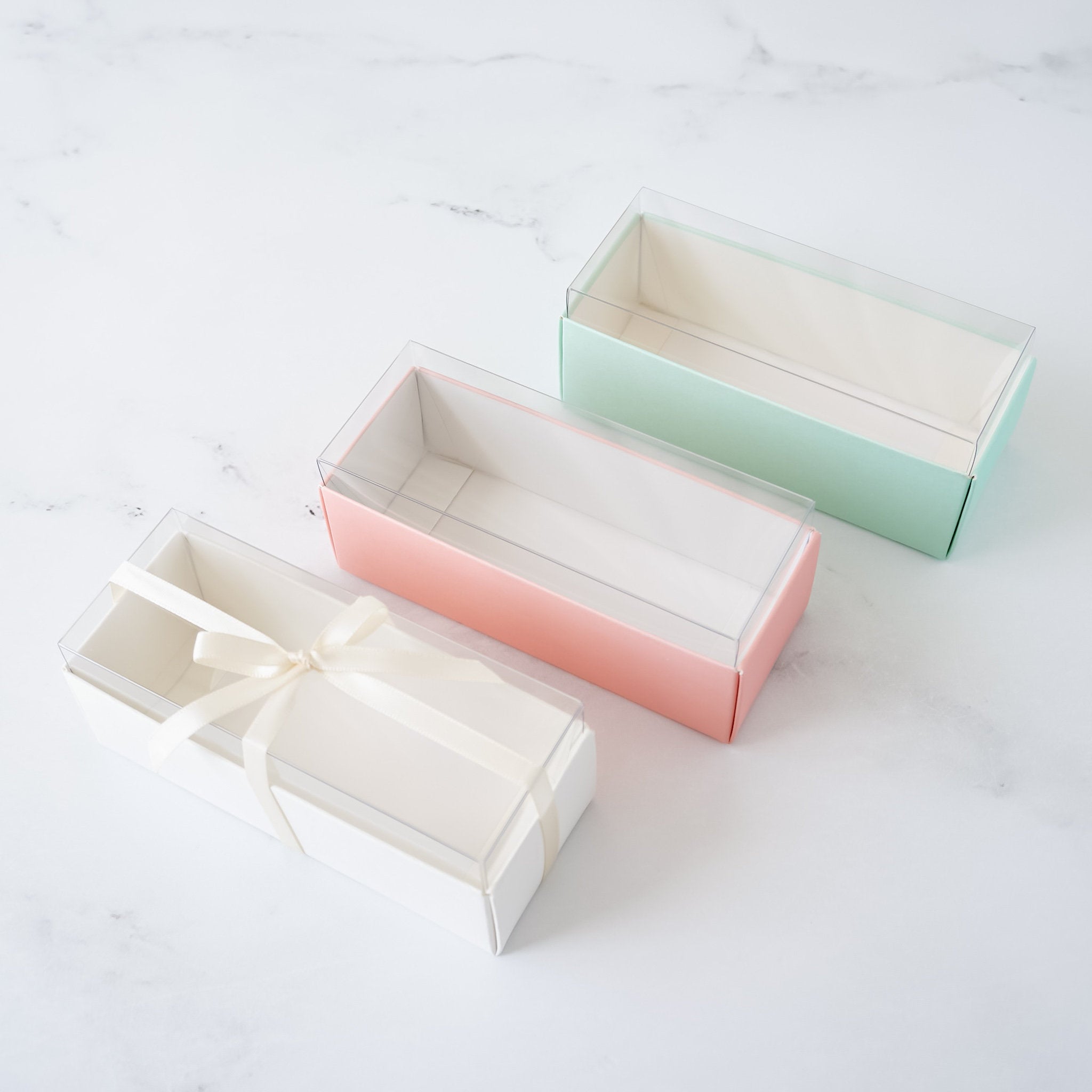 small macaron boxes in white, pink, and mint
